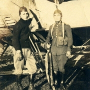 Dois homens, em vestimentas de aviação, posando para foto