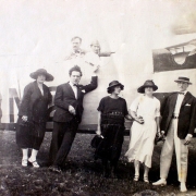 Quatro homens e três mulheres posando para uma foto na lateral de um avião em solo